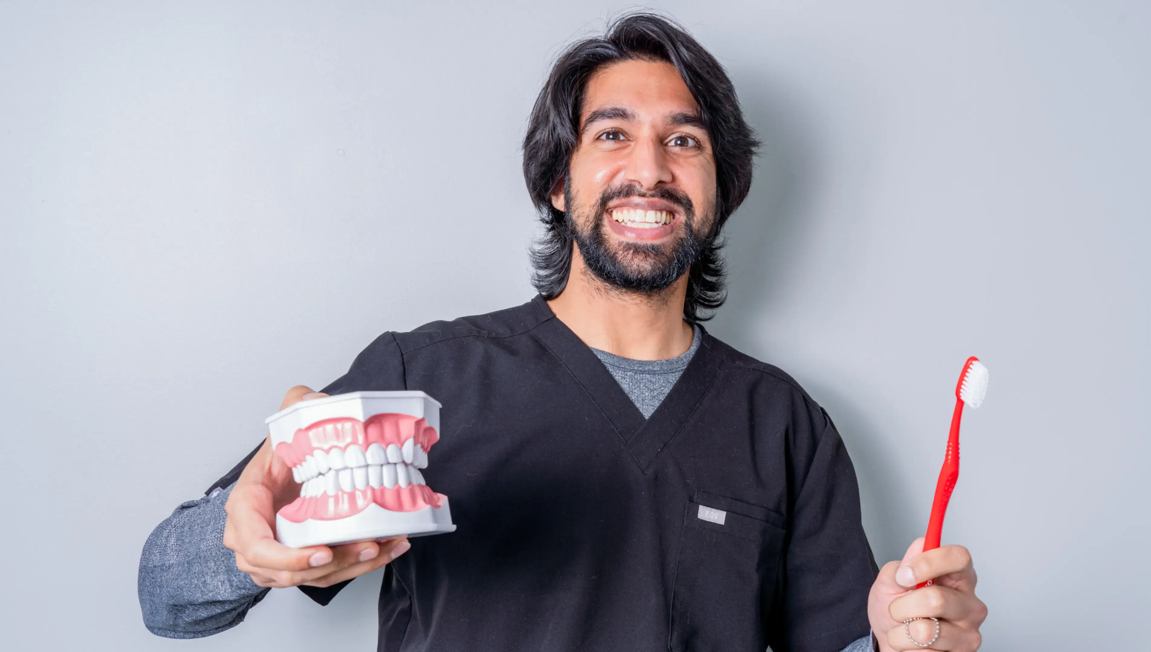 a man holding a toothbrush and a can of toothpaste